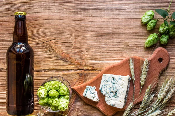 Fondo de cerveza. Cerveza fresca y queso salado en una mesa de madera. Vista superior — Foto de Stock