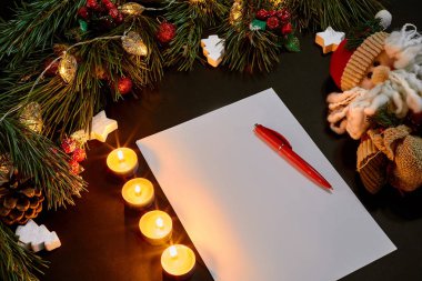 Kırmızı Noel topları ve siyah arka plan üzerine yeşil çam dal yakınındaki yalan defter görüntüleyin. Metin için yer