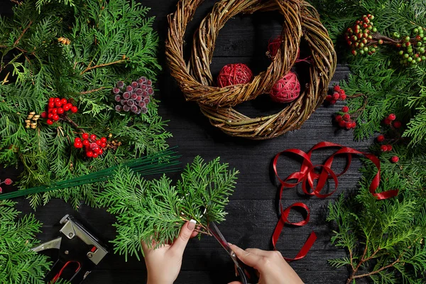 Fabricante de decoração de Natal com suas próprias mãos. Grinalda de Natal para o feriado. A celebração do ano novo. Vista superior — Fotografia de Stock