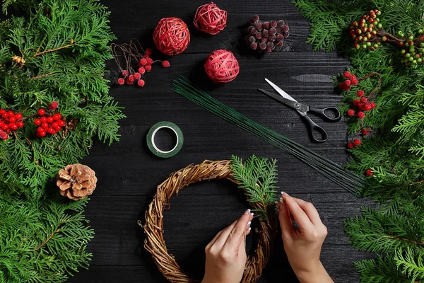 Fabricante de decoração de Natal com suas próprias mãos. Grinalda de Natal para o feriado. A celebração do ano novo. Vista superior — Fotografia de Stock