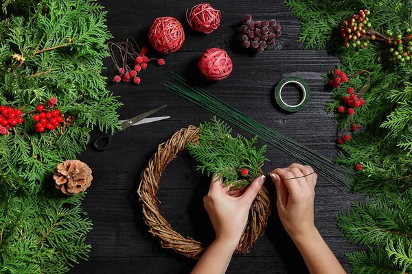 Hersteller von Weihnachtsdekoration mit ihren eigenen Händen. Weihnachtskranz für den Feiertag. das Neujahrsfest. Ansicht von oben — Stockfoto