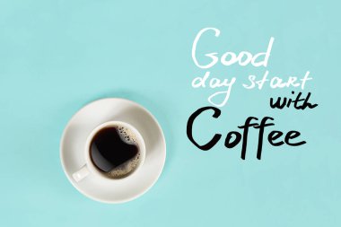 Fincan sade kahve ve kahve yazı üzerinde mavi arka plan izole ile iyi günler başlar Üstten Görünüm