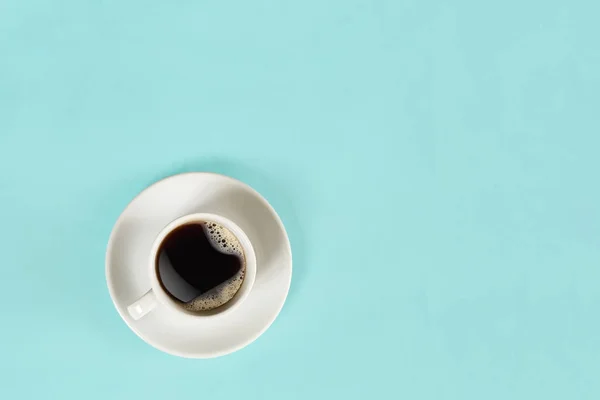 Una taza de café negro sobre fondo azul. Vista desde arriba . — Foto de Stock