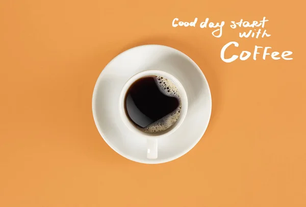 블랙 커피와 커피 글자 오렌지 배경에 격리와 좋은 하루 시작의 컵의 상위 뷰 — 스톡 사진