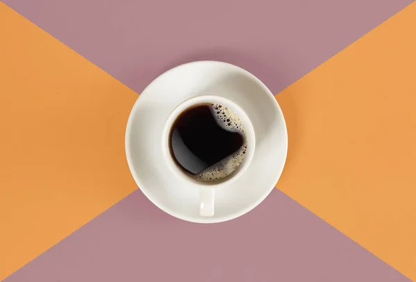 Una taza de café negro sobre fondo naranja y rojo. Vista desde arriba . — Foto de Stock