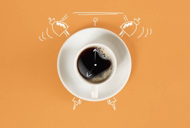 Saat. Saati ile taze espresso fincan portakal arka plan üzerinde oturum