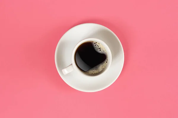 Una taza de café negro sobre fondo rosa. Vista desde arriba . — Foto de Stock
