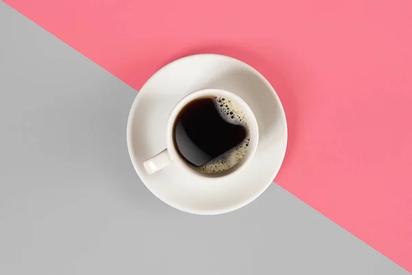 Una taza de café negro sobre fondo gris y rosa. Vista desde arriba . — Foto de Stock