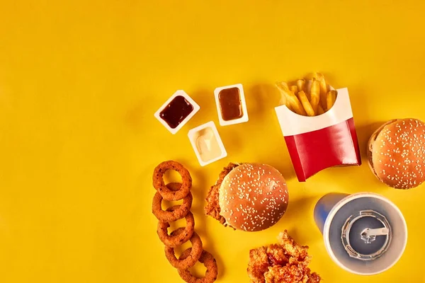 Гамбургер, картошка фри и жареная курица на желтом фоне. Пространство для копирования текста . — стоковое фото