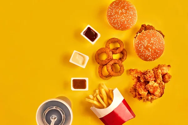 Вид зверху гамбургер, картопля фрі та смажена курка на жовтому тлі. Копіювати простір для вашого тексту . — стокове фото