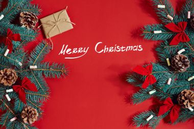 Köknar dalı ve hediye kutu kırmızı arka plan. Yazıt - Merry Christmas