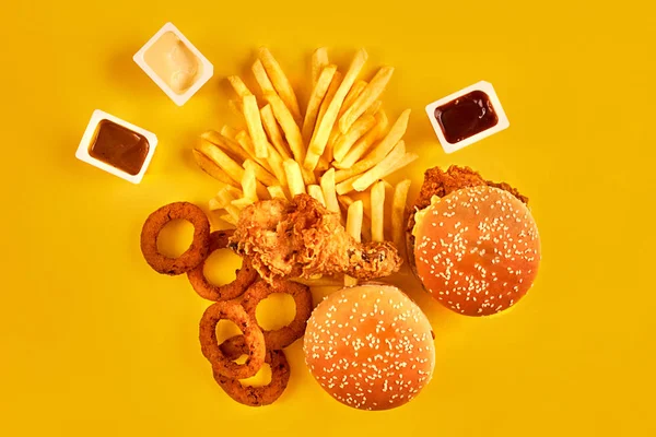 快餐和不健康的饮食概念-在黄色背景上的快餐小吃关闭 — 图库照片
