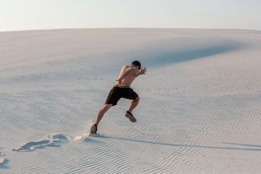 Hızlı kum üzerinde koşan adam uygun. Güçlü runner yaz açık eğitim.