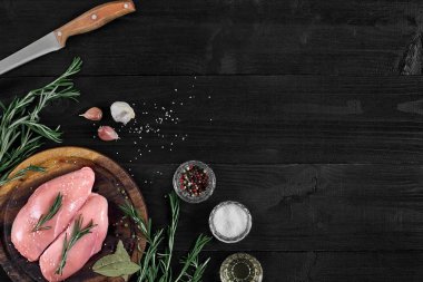 Otlar ve baharatlar ile ahşap kesme tahtası üzerinde çiğ tavuk göğsü fileto. kopya alanı ile Üstten Görünüm