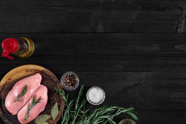 Otlar ve baharatlar ile ahşap kesme tahtası üzerinde çiğ tavuk göğsü fileto. kopya alanı ile Üstten Görünüm