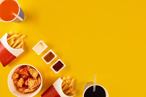 Fast food dish on yellow background. Fast food set fried chicken and french fries. Take away fast food.