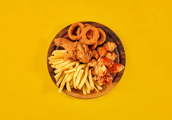 Fast food dish on yellow background. Fast food set fried chicken and french fries. Take away fast food.