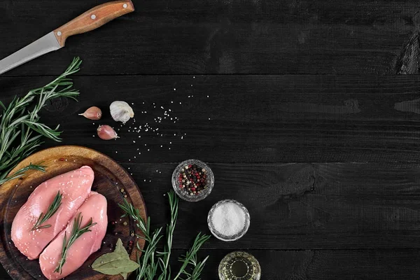 Otlar ve baharatlar ile ahşap kesme tahtası üzerinde çiğ tavuk göğsü fileto. kopya alanı ile Üstten Görünüm