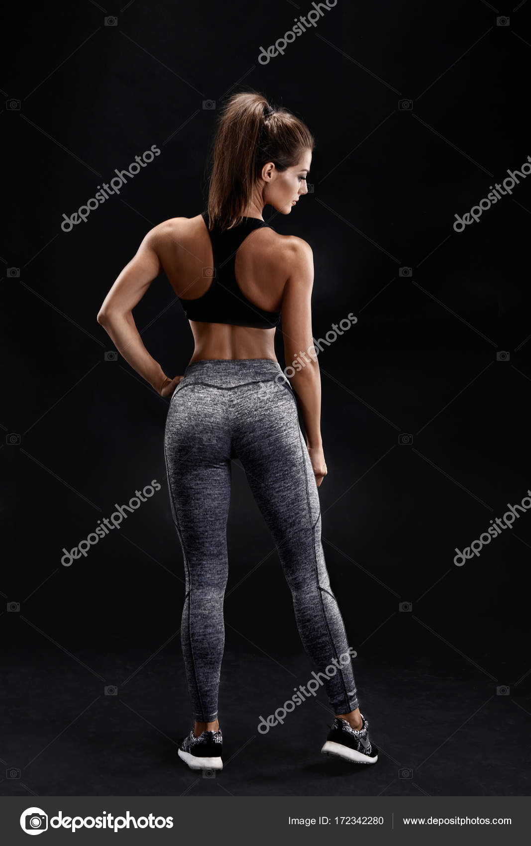 Shot of a strong woman with muscular abdomen in sportswear. Fitness female  model posing on black background. Stock Photo by ©nazarov.dnepr@gmail.com  172342280