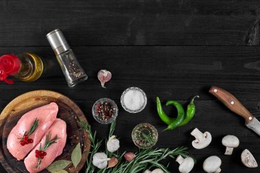 Çiğ tavuk göğsü fileto otlar, baharatlar, mantar ve biber ahşap kesme tahtası üzerinde. Kopya alanı ile Üstten Görünüm