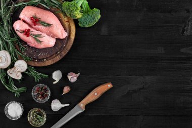 Çiğ tavuk göğsü fileto otlar, baharatlar ve sebzeler ile ahşap kesme tahtası üzerinde. Kopya alanı ile Üstten Görünüm