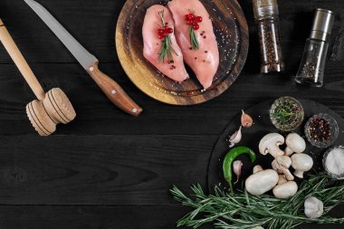 Otlar ve baharatlar ile ahşap kesme tahtası üzerinde çiğ tavuk göğsü fileto. kopya alanı ile Üstten Görünüm