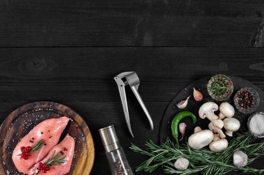 Otlar ve baharatlar ile ahşap kesme tahtası üzerinde çiğ tavuk göğsü fileto. kopya alanı ile Üstten Görünüm