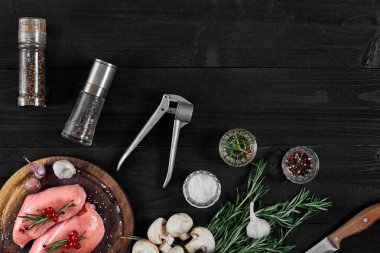 Otlar ve baharatlar ile ahşap kesme tahtası üzerinde çiğ tavuk göğsü fileto. kopya alanı ile Üstten Görünüm