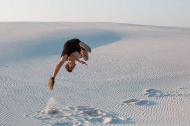 Man study parkour on their own. Acrobatics in the sand clipart