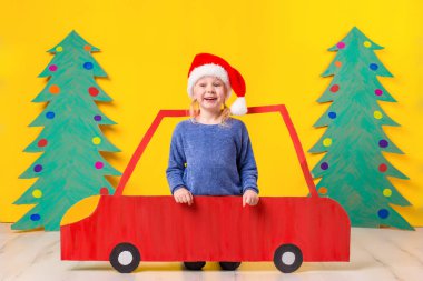 Çocuk Noel şapka karton bir araba ile. Noel kavramı. Yeni yıl tatilleri.