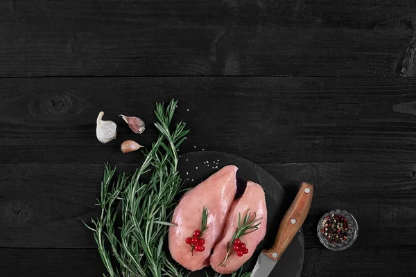 Gotowania piersi z kurczaka. Na stole są przyprawy - rozmaryn, czerwony i czarny pieprz. Koncepcja - zdrowa żywność. — Zdjęcie stockowe
