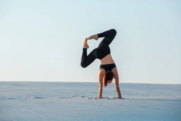 Junge Frau übt Inversion balancierende Yoga-Haltung Handstand auf Sand. — Stockfoto