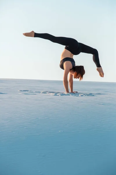 Junge Frau übt Inversion balancierende Yoga-Haltung Handstand auf Sand. — Stockfoto