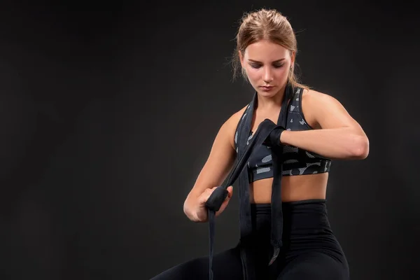 Jovem mulher apta embrulhando os braços com fita adesiva. Menina atraente se preparando para o treinamento de kickboxing . — Fotografia de Stock