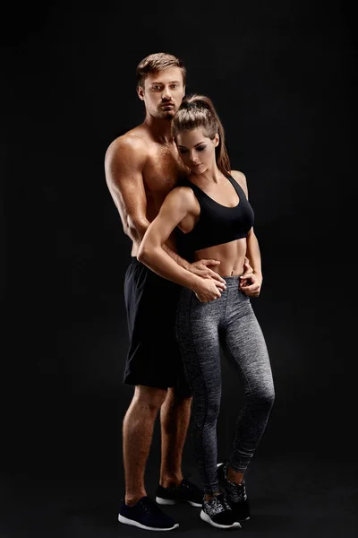 Spor, fitness, egzersiz kavramı. Çift, güçlü kas adam ve siyah bir arka plan üzerinde poz ince kadın uygun — Stok fotoğraf