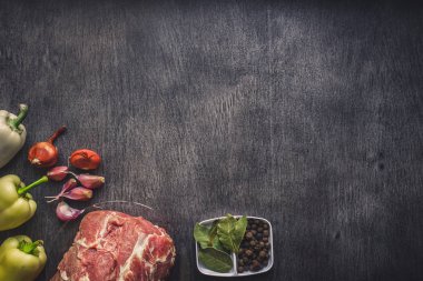 Çiğ domuz eti koyu ahşap yüzey ve yemek pişirmek için malzemeler. Gıda arka plan kopya alanı ile.