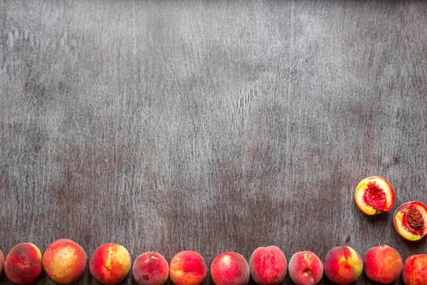 Frutas frescas de melocotones sobre fondo rústico de madera oscura, vista superior — Foto de Stock