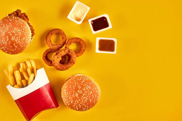 快餐和不健康的饮食概念-在黄色背景上的快餐小吃关闭 — 图库照片