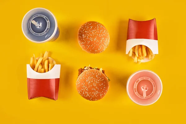 Fast food ve sağlıksız beslenme kavramı - kadar yakın lokanta aperatifler ve soğuk içecek Sarı zemin üzerine — Stok fotoğraf