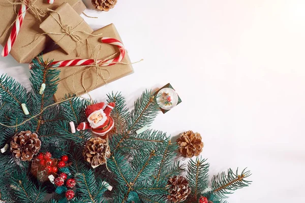 Christmas or New Year background: fur-tree, branches, gifts, decoration on a white background. Sun flare