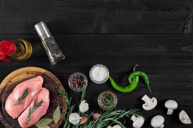 Çiğ tavuk göğsü fileto otlar, baharatlar, mantar ve biber ahşap kesme tahtası üzerinde. Kopya alanı ile Üstten Görünüm