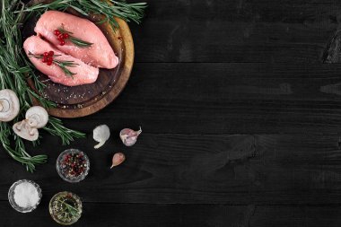 Çiğ tavuk göğsü fileto otlar, baharatlar ve mantar ile ahşap kesme tahtası üzerinde. Kopya alanı ile Üstten Görünüm