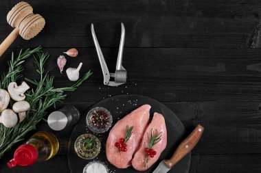 Tavuk göğsü rustik ahşap arka plan üzerinde farklı sebze ve otlar ile kesme tahtası.