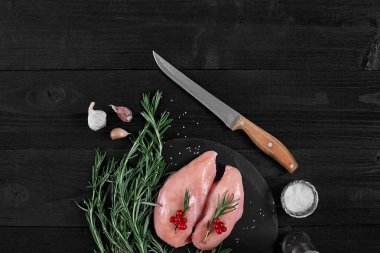 Pişirme tavuk göğsü. Masanın üzerine baharat - biberiye, kırmızı ve karabiber vardır. Kavram - sağlıklı gıda.