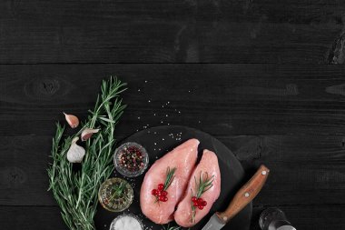 Pişirme tavuk göğsü. Masanın üzerine baharat - biberiye, kırmızı ve karabiber vardır. Kavram - sağlıklı gıda.