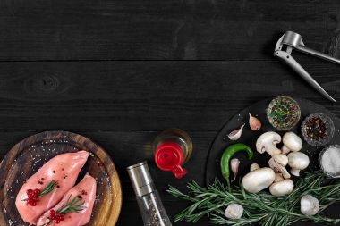 Otlar ve baharatlar ile ahşap kesme tahtası üzerinde çiğ tavuk göğsü fileto. kopya alanı ile Üstten Görünüm