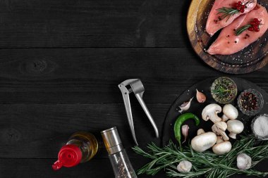 Otlar ve baharatlar ile ahşap kesme tahtası üzerinde çiğ tavuk göğsü fileto. kopya alanı ile Üstten Görünüm