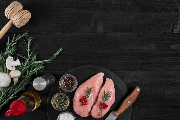 Tavuk göğsü rustik ahşap arka plan üzerinde farklı sebze ve otlar ile kesme tahtası.