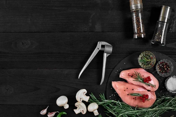 Tavuk göğsü rustik ahşap arka plan üzerinde farklı sebze ve otlar ile kesme tahtası.