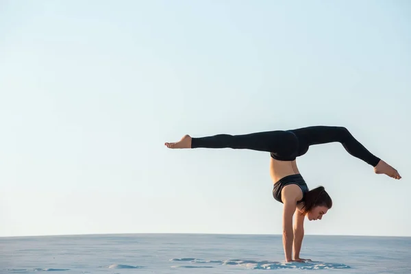 Junge Frau übt Inversion balancierende Yoga-Haltung Handstand auf Sand. — Stockfoto